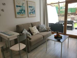 sala de estar con sofá y mesa en SUNNY CACTUS GARDEN Apartment 150m from beach, fast Fiber Wifi en San Bartolomé