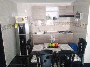 una pequeña cocina con mesa y nevera en Apartamento acogedor con Piscina Excelente Sector, en Ibagué