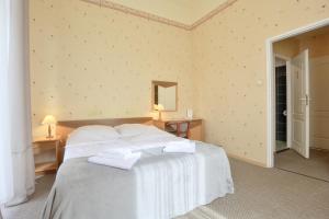 um quarto com uma cama branca com duas toalhas em Muza em Duszniki Zdrój