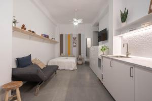a kitchen and living room with a couch and a bed at NICE and COSY LOFTS CITY CENTER 1&2 in Málaga