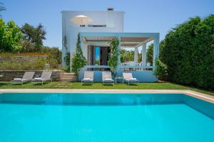 a villa with a swimming pool and a house at Sofia Luxury Villas in Panormos Rethymno