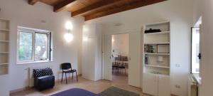 un soggiorno con pareti bianche, finestra e sedia di Bivano BioMele a Policoro
