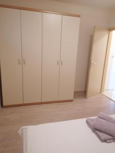 a bedroom with white cabinets and a mirror at Salona Croatia in Solin