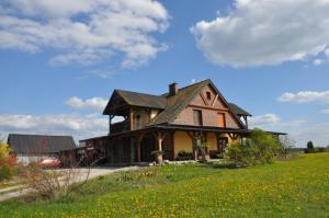 een huis op een heuvel met een groen veld bij Agroturystyka Bogdanki in Stary Targ