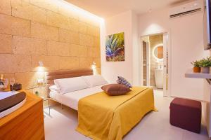 1 dormitorio con 1 cama con mesa y baño en Porta del Golfo Apartments & Suites, en Castellammare del Golfo