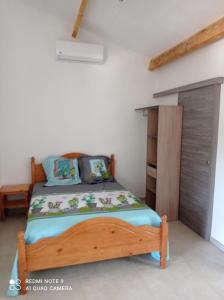 a bedroom with a wooden bed in a room at Maisonnette A Santa Ghjulia entre Mer & Montagne in Volpajola