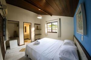 ein Schlafzimmer mit einem großen weißen Bett in einem Zimmer in der Unterkunft Qavi - Villa di Milos - Praia da Pipa in Pipa