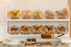 - un paquet de paniers de pain et de pâtisseries sur les étagères dans l'établissement LOBOS VILLAGE - Alojamento, à Seia