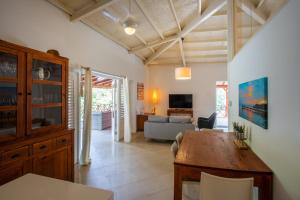 uma sala de estar com uma mesa de madeira e um sofá em Villa Bougainville em Willemstad