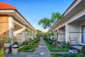 a courtyard of a house with trees and plants at Kubu Dimel Suites and Villas Resort in Nusa Dua