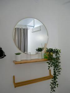 a mirror on a shelf with a shower curtain at Plage Cabourg 5bis in Cabourg