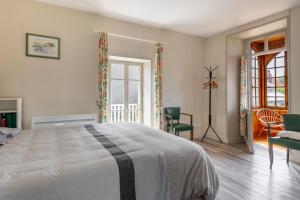 - une chambre avec un grand lit et des chaises dans l'établissement Maison avec beau jardin - Centre ville d'Arromanches, à Arromanches-les-Bains