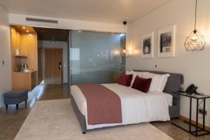 a bedroom with a large bed and a walk in shower at LOBOS VILLAGE - Alojamento in Seia