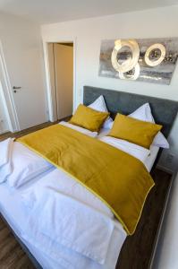 a bedroom with a large bed with yellow sheets and pillows at Altstadt Hotel Self Check-In in Würzburg