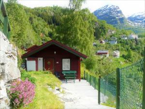 una pequeña casa en una colina con una valla en Hole Hytter en Geiranger