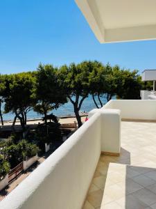 a balcony with a view of the beach and trees at Attico Margherita - LA TERRAZZA SUL MARE in Gallipoli