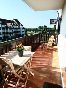 eine Terrasse mit einem Tisch und Stühlen auf dem Balkon in der Unterkunft Plage Cabourg 5bis in Cabourg