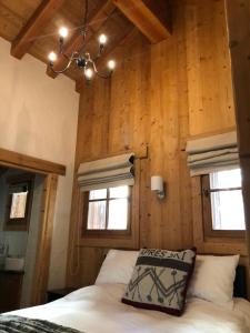a bedroom with wooden walls and a bed with a pillow at Chalet Rose in Saint-Martin-de-Belleville