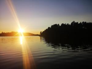 a sunset over a lake with the sun setting at EKO Domek u Siemion in Raczki +15 photos