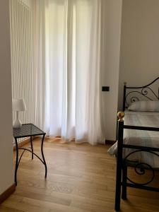 - une chambre avec un lit, une table et une fenêtre dans l'établissement APPARTAMENTO AL FORTE, à Rivoli Veronese