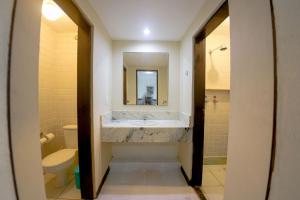 a bathroom with a tub and a sink and a toilet at Pousada Villa di Milos - By Quarto à Vista in Pipa +46 photos