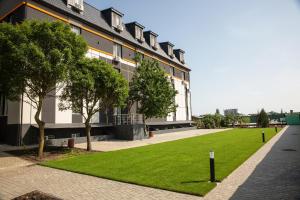 a building with a green lawn in front of it at Аквамарин in Gribovka