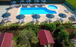 an overhead view of a pool with chairs and umbrellas at Аквамарин in Gribovka