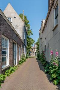 an alley between two brick buildings with flowers at Slapen bij Van-V in Zierikzee