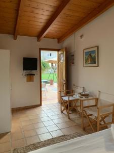 a living room with a table and a television at The Orange Grove Garden Room in Mytikas