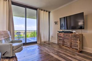 a living room with a large flat screen tv at Dauphin Island Condo with Pool, Balcony and Ocean View in Dauphin Island