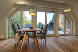una sala da pranzo con tavolo e sedie in legno di Schilfkante - Am Ufer a Wieck