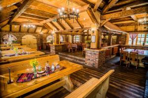 uma grande sala com mesas e cadeiras num edifício em Hotel Enigma em Žabljak