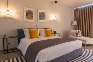 - une chambre avec un grand lit et une chaise dans l'établissement LOBOS VILLAGE - Alojamento, à Seia