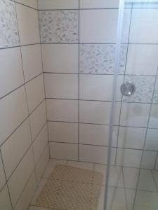 a shower with a glass door and a rug at Apartament Nicoleta in Jurilovca