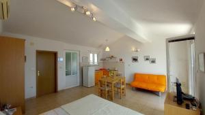 uma sala de estar com um sofá laranja e uma mesa em Apartmani Antonini 2 em Živogošće