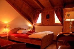 a bedroom with a bed in a room with wooden ceilings at Garni Biancaneve Ruffrè-Mendola in Mendola