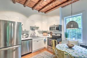 a kitchen with white cabinets and a table with chairs at Charming Jaffrey Cottage with Deck and Grill! in Jaffrey