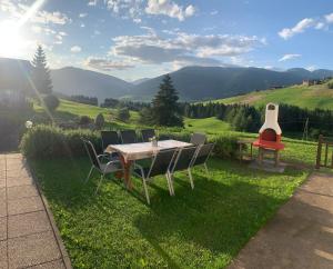 uma mesa e cadeiras sentadas na relva com uma guitarra em Ferienhaus Köck em Kartitsch