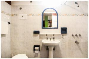 a bathroom with a sink and a mirror at El Camino Hostel in Mina Clavero