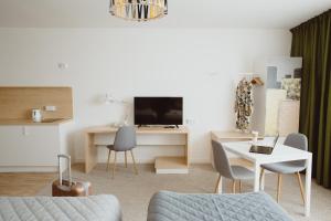 salon z kanapą, stołem i telewizorem w obiekcie Arche Hotel Poloneza w Warszawie