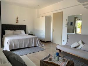 a bedroom with a bed and a couch at Swash & Ripple Studio by the sea in Mytikas