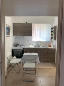 a small kitchen with a table and chairs in it at Swash & Ripple Studio by the sea in Mytikas