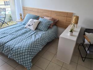 a bedroom with a bed with a blue comforter and pillows at Chez Malo in Perros-Guirec