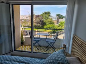 a bedroom with a bed and a balcony with a table at Chez Malo in Perros-Guirec