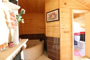 Baño con bañera en la esquina de una habitación en Assortie La Villa Hotel, en Agva