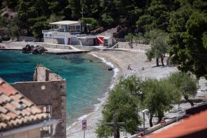 a view of a beach with people in the water at Komiza Provita Guesthouse in Komiža