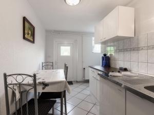 a kitchen with white cabinets and a table in it at Pleasant Apartment in Damshagen with Terrace and Barbecue in Damshagen