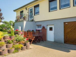 a house with a table and chairs and flowers at Pleasant Apartment in Damshagen with Terrace and Barbecue in Damshagen