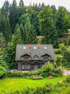 a wooden house in the middle of a field at Penzion Zelené Údolí in Janske Lazne