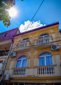 um edifício amarelo com janelas e uma varanda em Good Times Luxury Apartments Bitola em Bitola